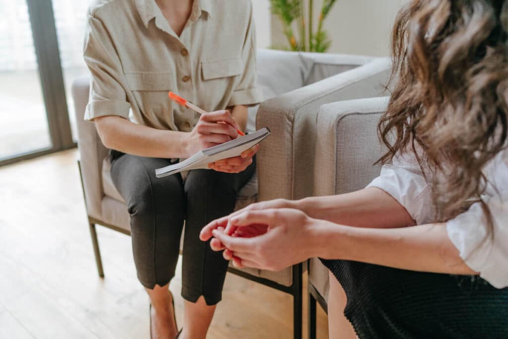 Nahaufnahme einer jungen Frau, die in einem Beratungsgespräch mit einem Arzt über ihre psychischen Probleme spricht. Konzept der psychischen Gesundheit. Selektiver Fokus.