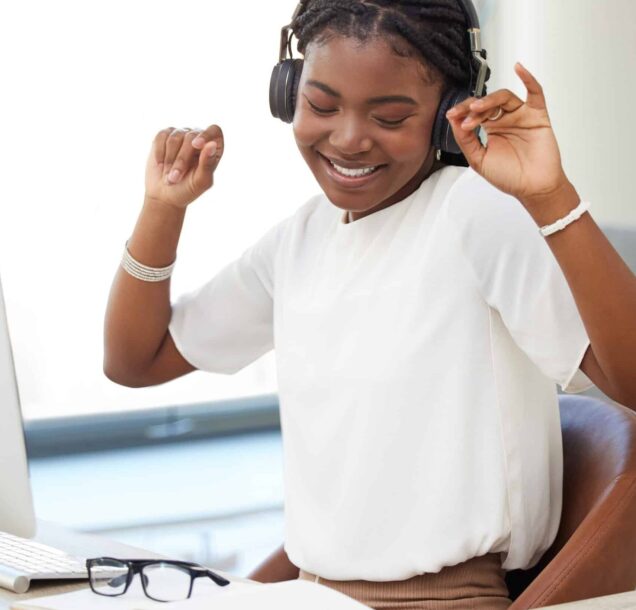 Dance, headphones and woman on computer, office or workplace for mental health, wellness and listening. Happy african person working on desktop pc and dancing to music, celebration and job or career.