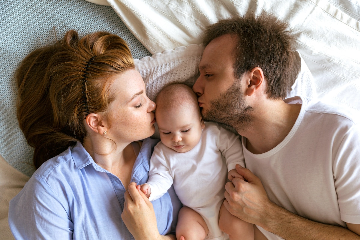 Mutter und Vater mit einem drei Monate alten Baby. Schöne junge Familie in Elternzeit. Aufnahme von oben - work-life-balance