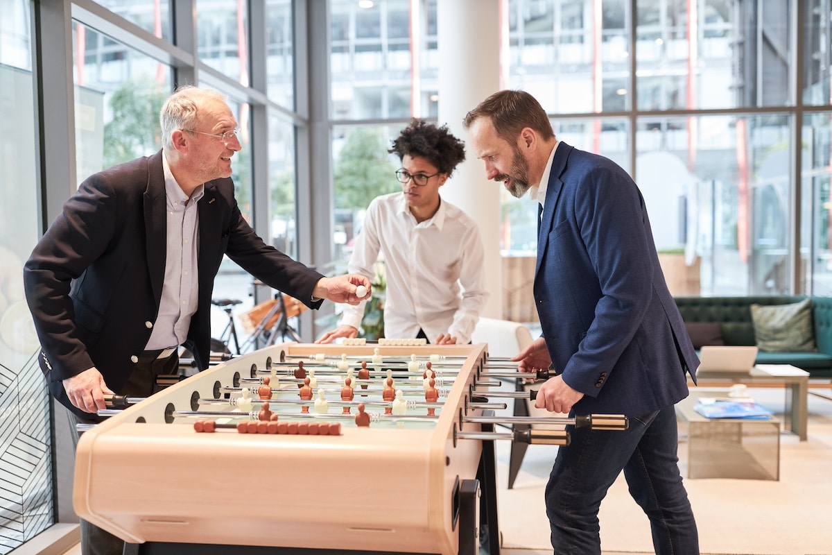 Les hommes d'affaires jouent au baby-foot pour se détendre lors d'une pause au bureau -