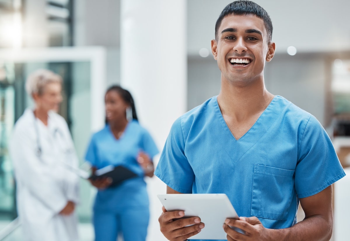 Tablet, healthcare and medicine with a man nurse doing research in a hospital for health or treatment. Medical, insurance and medicare with a young male clinic worker doing a search online. - protecting caregivers