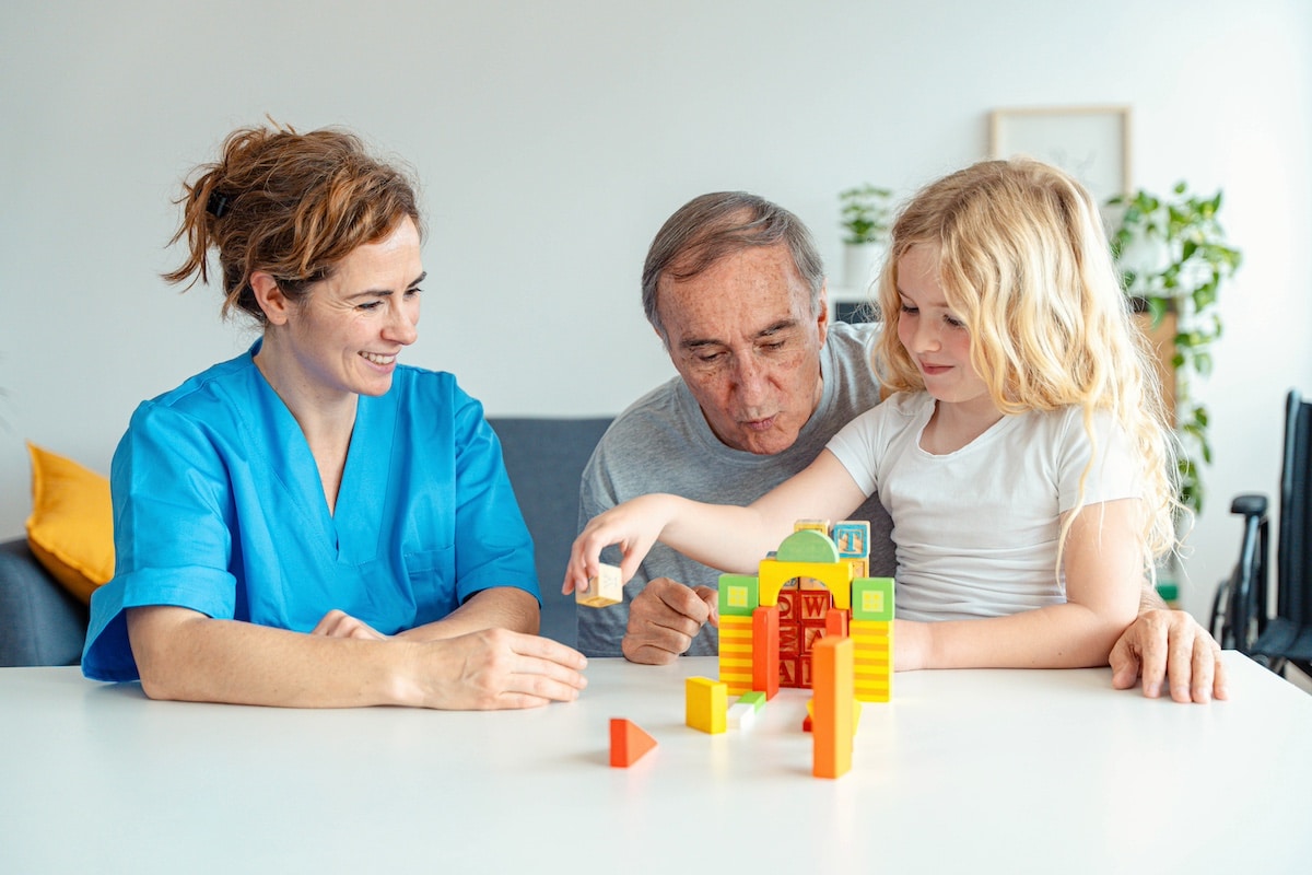 Professional nurse caregiver in geriatric clinic helps senior man with Alzheimer's disease - Old patient playing puzzle in retirement home - Healthcare and medical concept - protecting caregivers