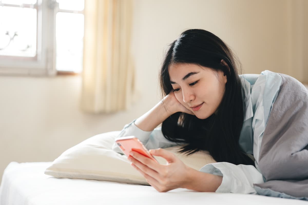 Lifestyle with modern technology concept. Happy young adult lonely single woman holding smartphone in the moring for telemedicine and mental health concept. - corporate health