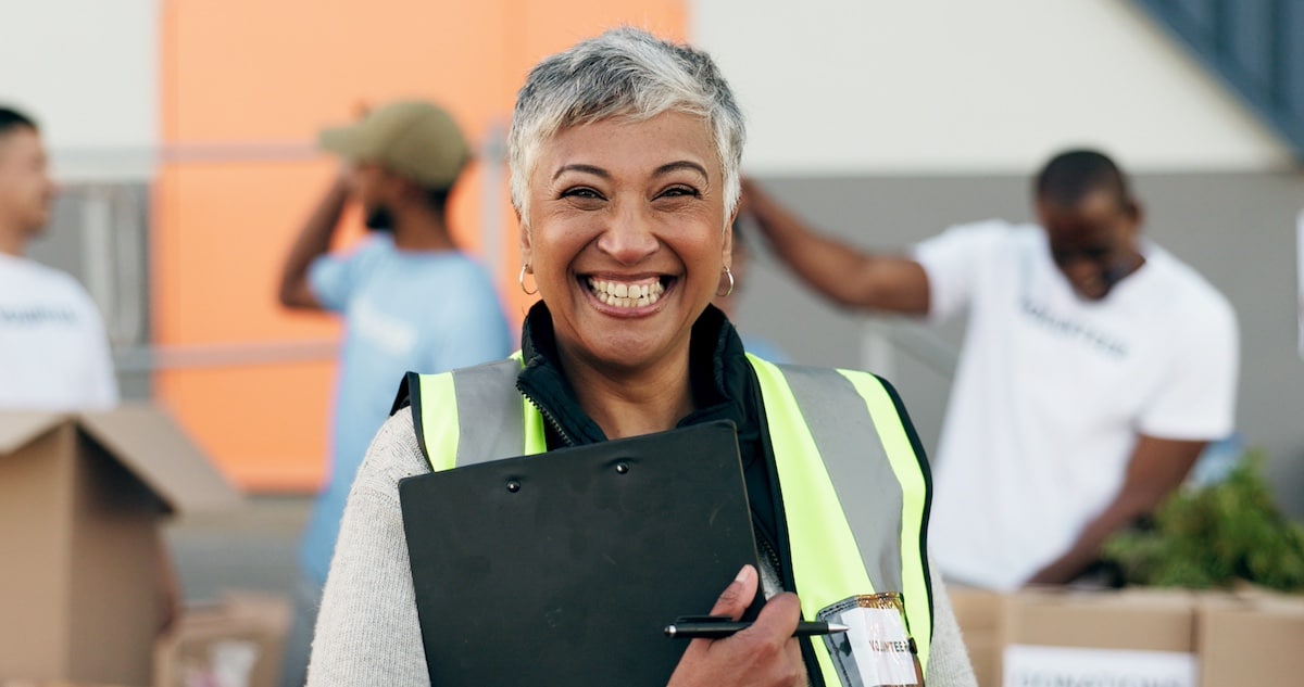 Woman, clipboard and donation for charity, volunteer and organizer for outreach program, smile and portrait. Happy senior person, non profit and support in social responsibility for NGO foundation. - health program