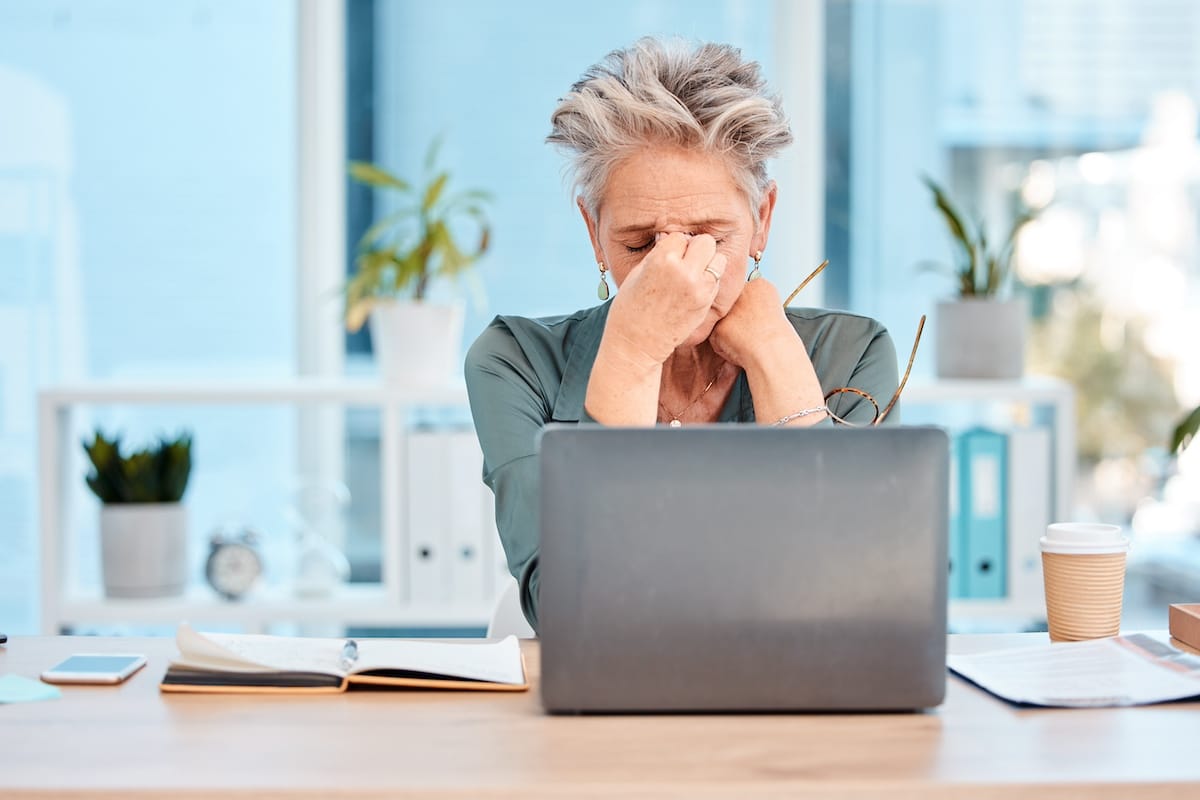 Stress, Kopfschmerzen und eine Frau mit Laptop, psychische Gesundheit und Angst im Büro. Depression, Geschäftsfrau und Unternehmerin mit Burnout-Erfahrung, unglücklich, überarbeitet und Schmerzen bei der Gründung eines Unternehmens - Arbeitsschutz