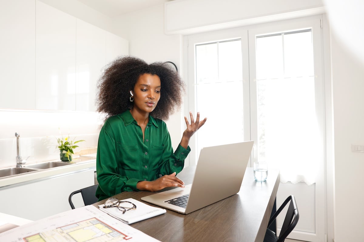 Frau vor einem Computer, die von zu Hause aus arbeitet -