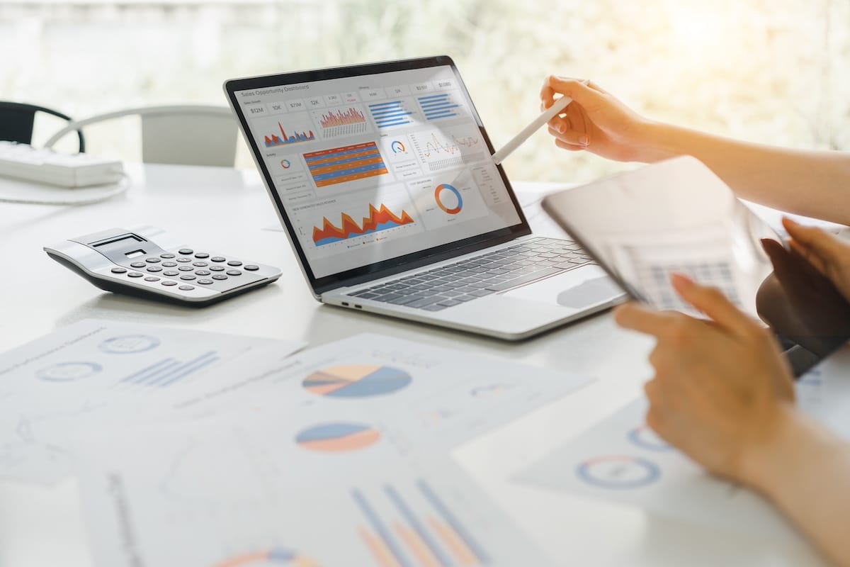 Professional analyzing financial data graphs, charts on laptop display at a modern workspace. Financial analysis or business evaluation concept -