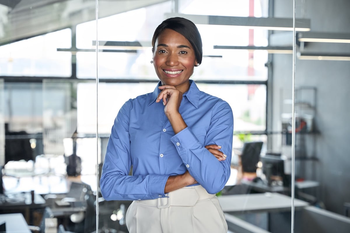 Happy confident young professional business woman ceo corporate leader, smiling female African American businesswoman lawyer or hr manager wearing blue shirt standing in office, portrait. - workplace wellbeing